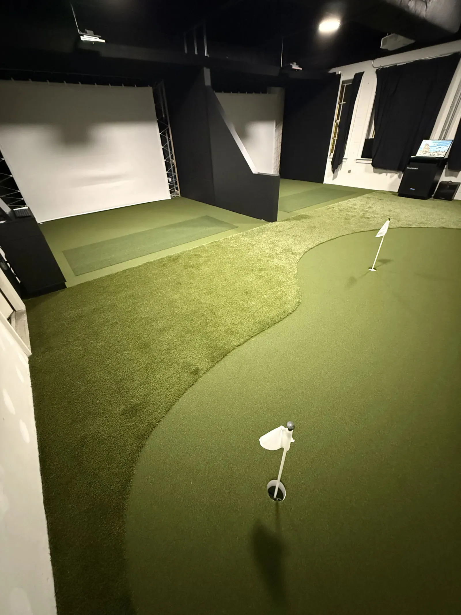 Indoor golf simulator room with putting green in Winston-Salem